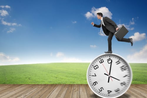 Businessman running on a large clock, symbolizing life time