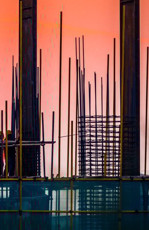 Steel building site with builders and sunset