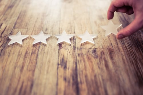 En gengrebild som visar en hand som lägger stjärnsymboler efter varandra på ett bord som exemplifierar metodisk process för att nå framgång.