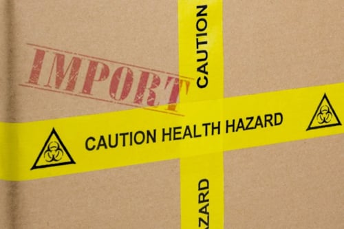 En förpackning i kartong, med fokus på en gul tejp med varningstext.