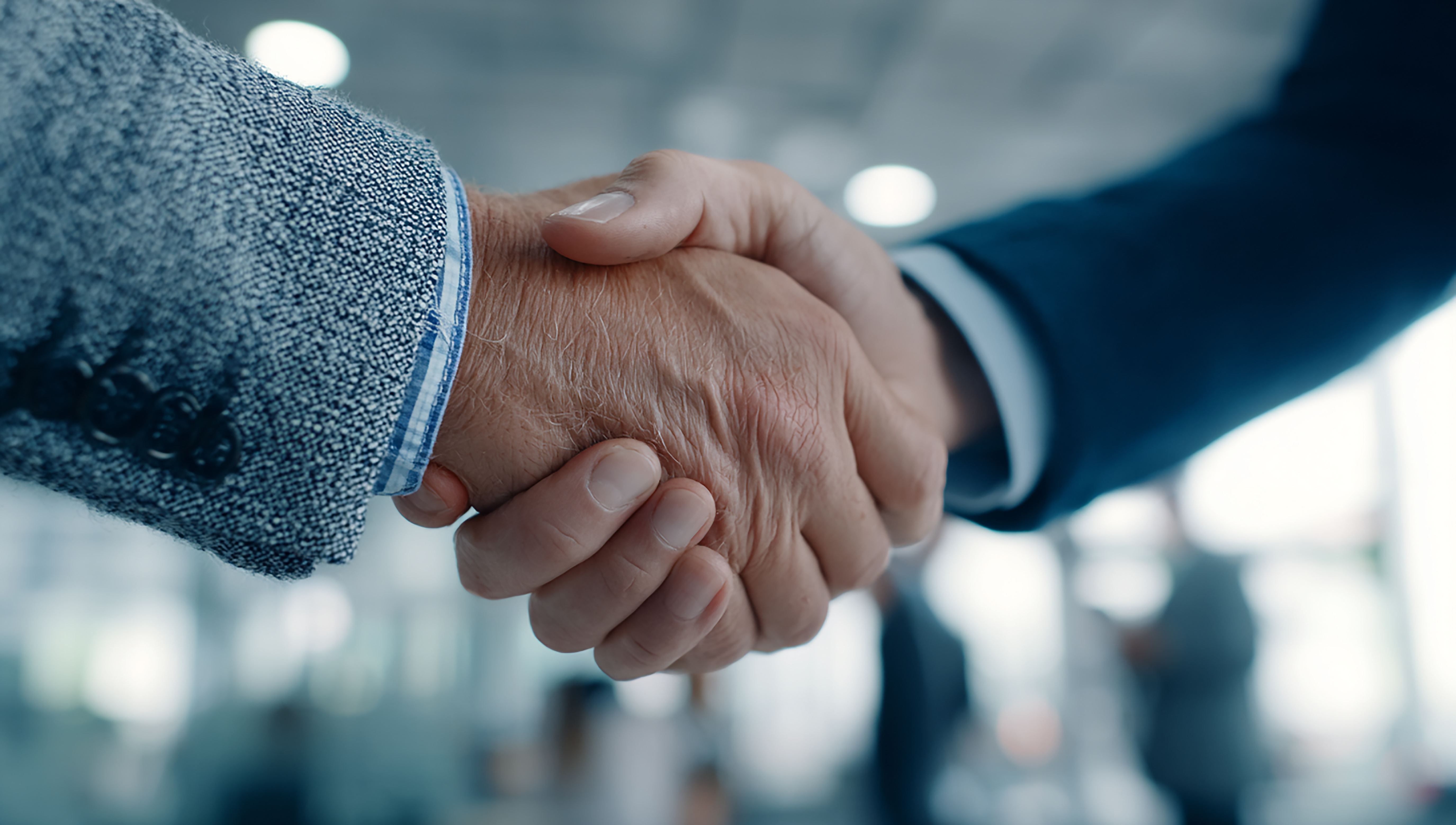 Close-up of two people shaking hands in a business setting