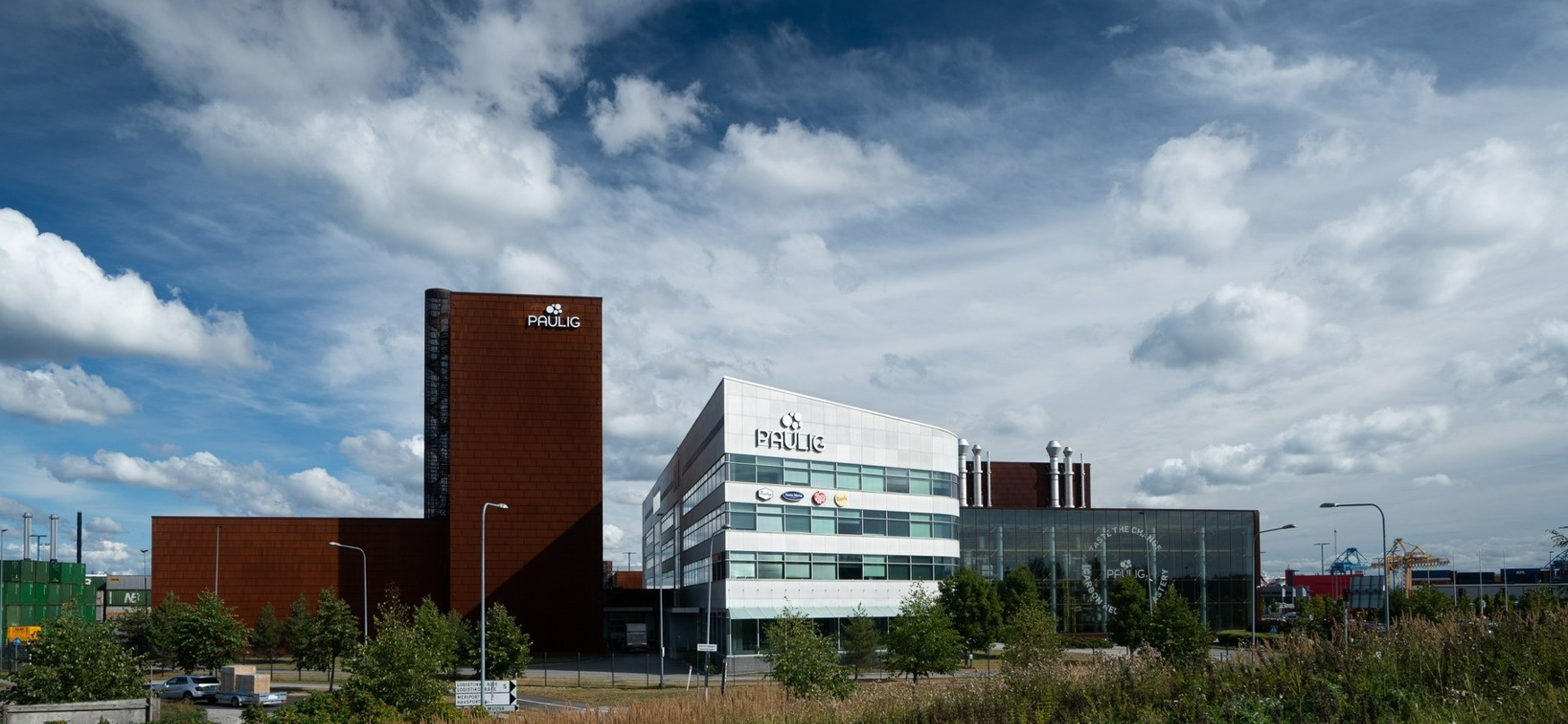 Den moderna kontorsbyggnaden Paulig med en vit och brun fasad under en molnig himmel.