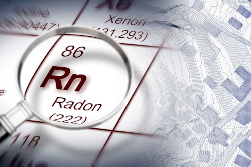 Ett förstoringsglas visualiserar ett fokus på radon i det periodiska systemets lista av grundämnen. Fastighetsägaren är ansvarig för radonmätningen i sina fastigheter.