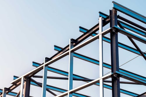 Stålkonstruktion med balkar mot klar himmel.
