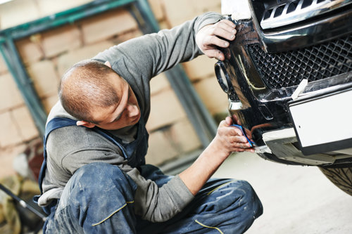 Mechanic working on the front of a car