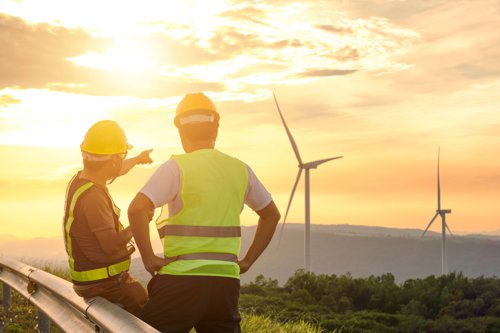 two engineers with neon vests look and discuss renewable energy source